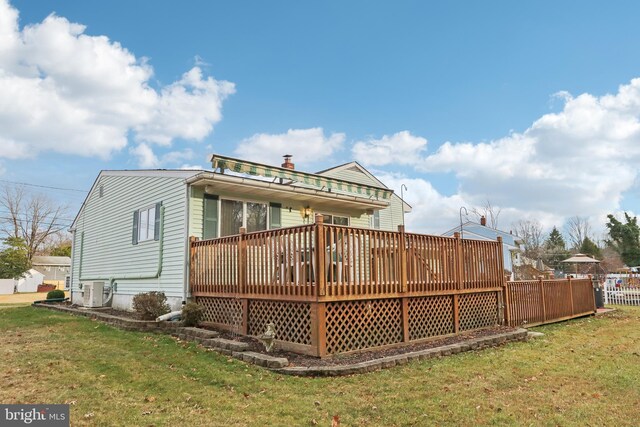 rear view of property featuring a yard and a deck