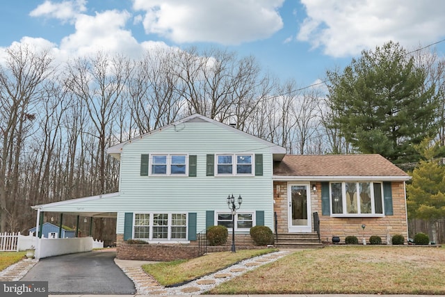 split level home featuring a front lawn and a carport