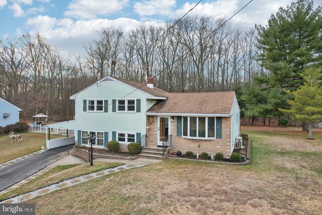 tri-level home featuring a front lawn and a carport