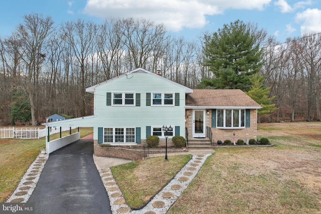 tri-level home featuring a front yard and a carport