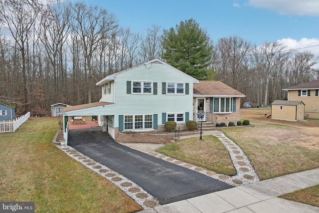 view of front facade with a carport, a shed, and a front yard