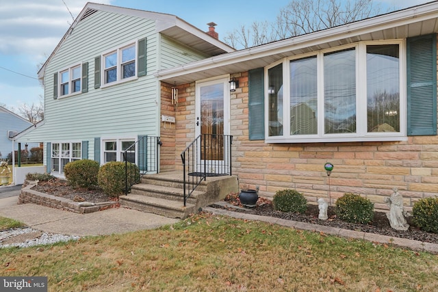 tri-level home featuring a front lawn