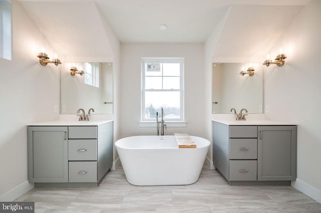 bathroom with a washtub and vanity