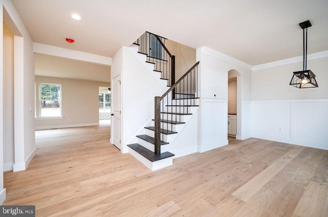 staircase featuring hardwood / wood-style floors and crown molding