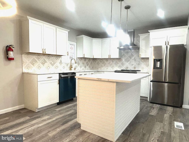 kitchen with stainless steel refrigerator with ice dispenser, wall chimney range hood, decorative light fixtures, black dishwasher, and white cabinetry