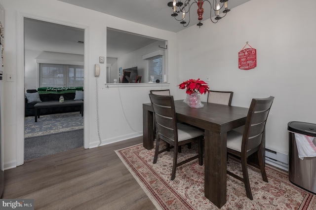 dining area featuring wood-type flooring and a notable chandelier