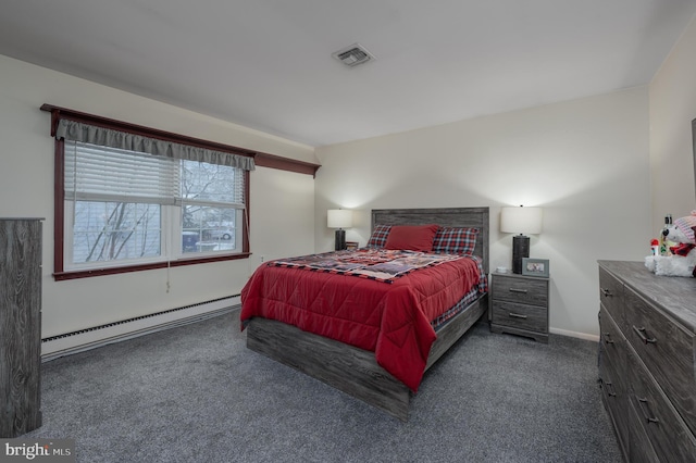 bedroom with dark colored carpet and a baseboard heating unit