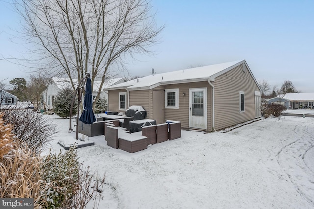 snow covered house with an outdoor living space