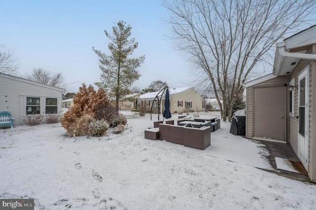 snowy yard featuring outdoor lounge area