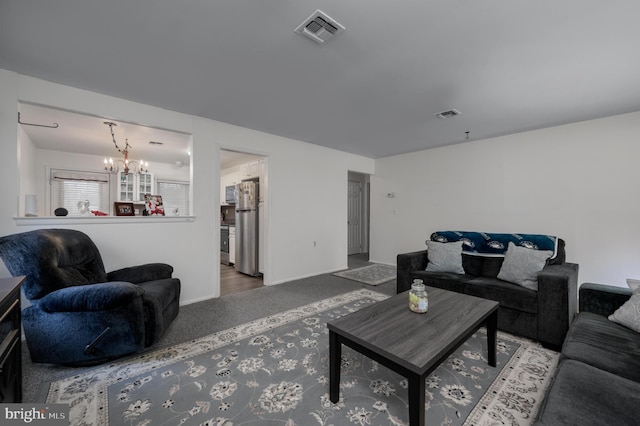 living room featuring carpet floors and a notable chandelier