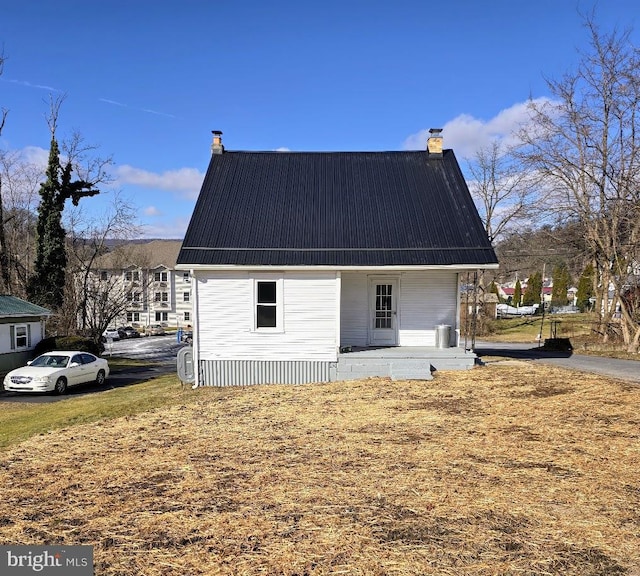 view of property exterior with covered porch and a yard