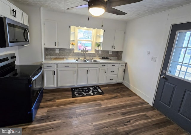 kitchen with white cabinets, ceiling fan, dark wood-type flooring, sink, and black electric range