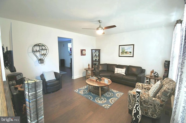 living room with ceiling fan and dark hardwood / wood-style flooring