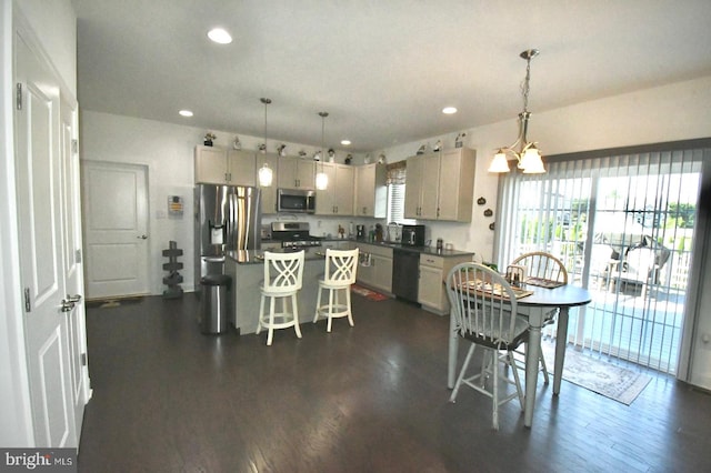 kitchen with a breakfast bar, pendant lighting, a center island, and appliances with stainless steel finishes