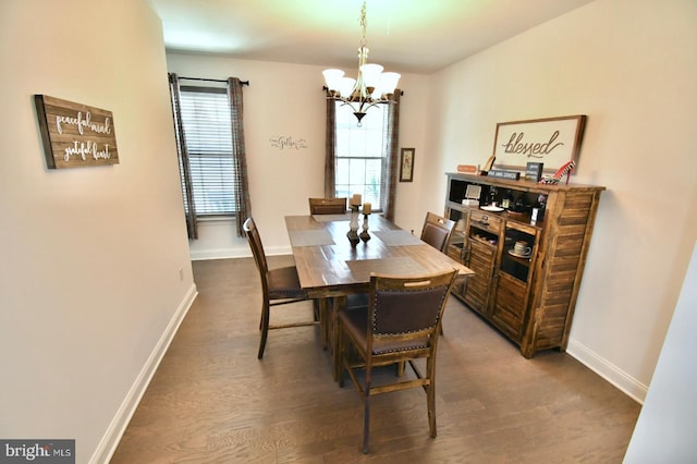 dining area with wood-type flooring, an inviting chandelier, and plenty of natural light