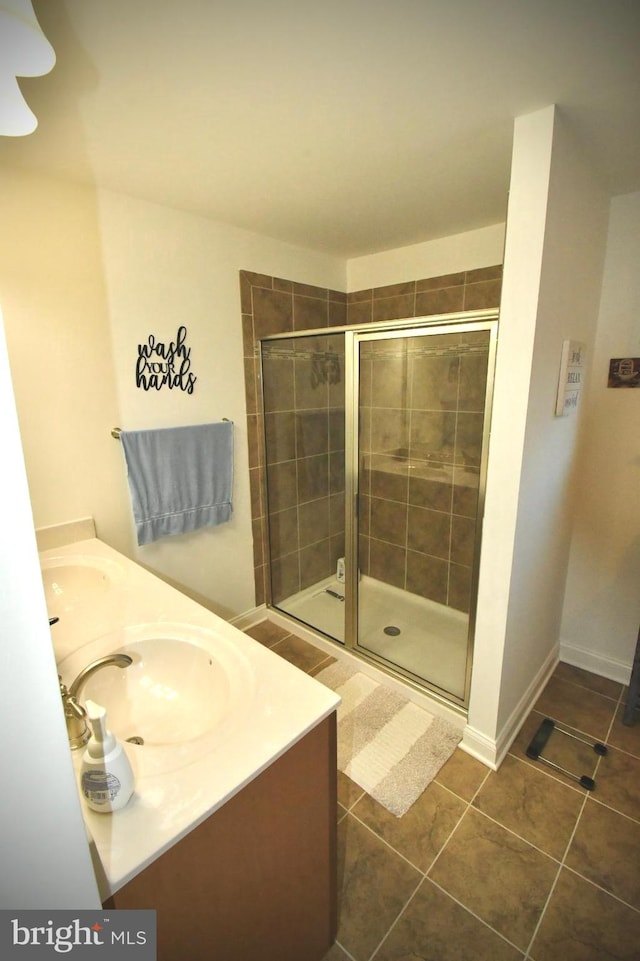 bathroom with tile patterned flooring, vanity, and an enclosed shower