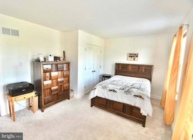 bedroom with light carpet and a closet