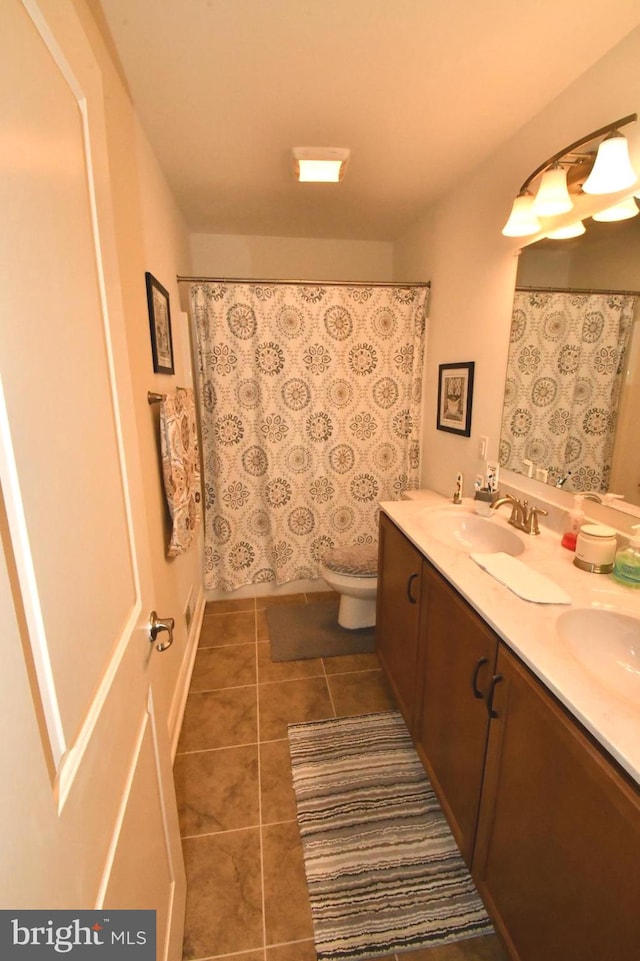 bathroom with tile patterned flooring, vanity, toilet, and curtained shower