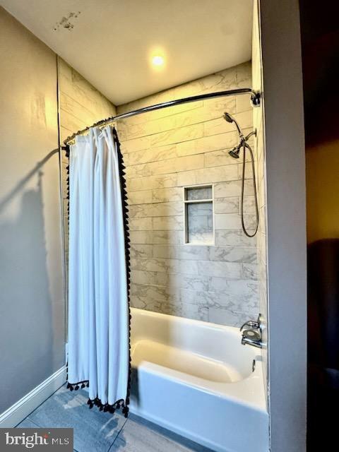 bathroom with tile patterned floors and shower / bath combination with curtain