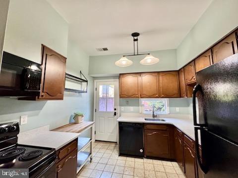 kitchen with hanging light fixtures, black appliances, and sink