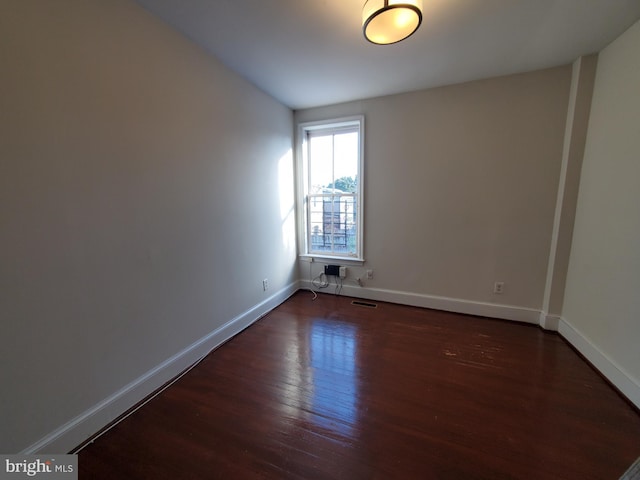 empty room with dark hardwood / wood-style flooring