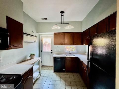 kitchen with hanging light fixtures, black appliances, and sink