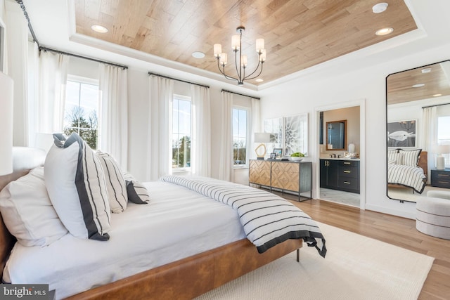 bedroom with light wood-type flooring, a raised ceiling, ensuite bath, and wood ceiling