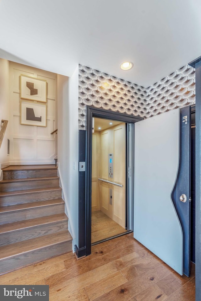 stairs featuring hardwood / wood-style floors