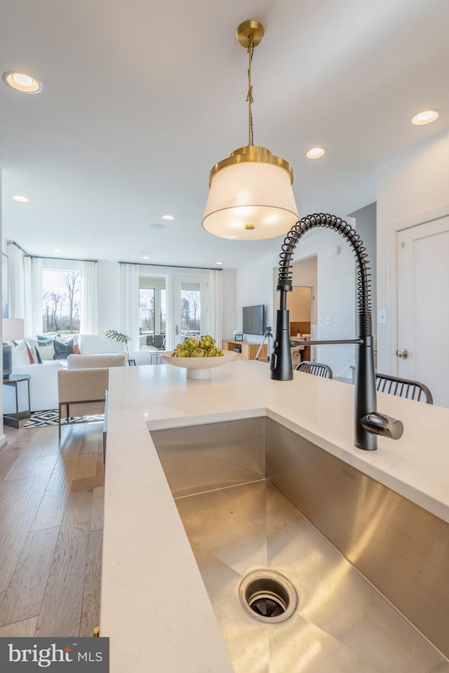 room details featuring pendant lighting, wood-type flooring, and sink