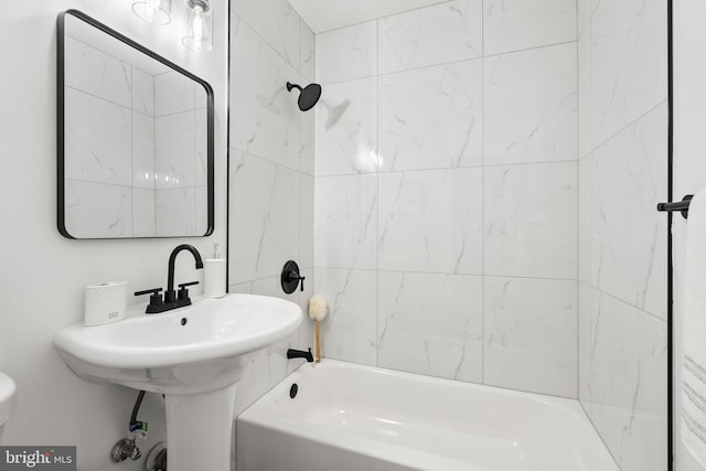 bathroom with toilet and tiled shower / bath