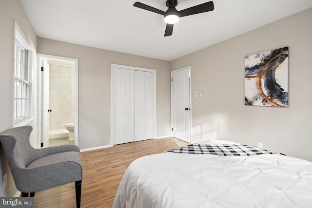 bedroom with ceiling fan, connected bathroom, multiple windows, light hardwood / wood-style floors, and a closet