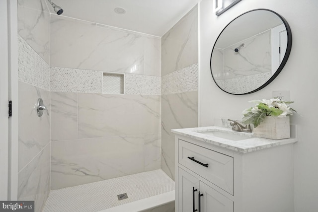 bathroom with vanity and a tile shower