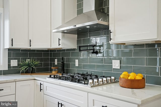 kitchen featuring backsplash, white cabinets, and wall chimney exhaust hood