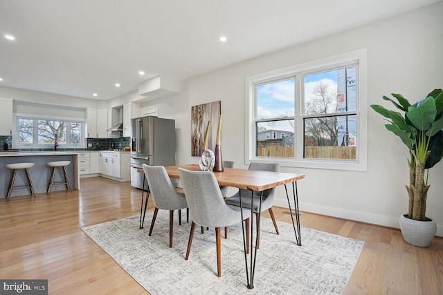 dining area with light hardwood / wood-style flooring and sink