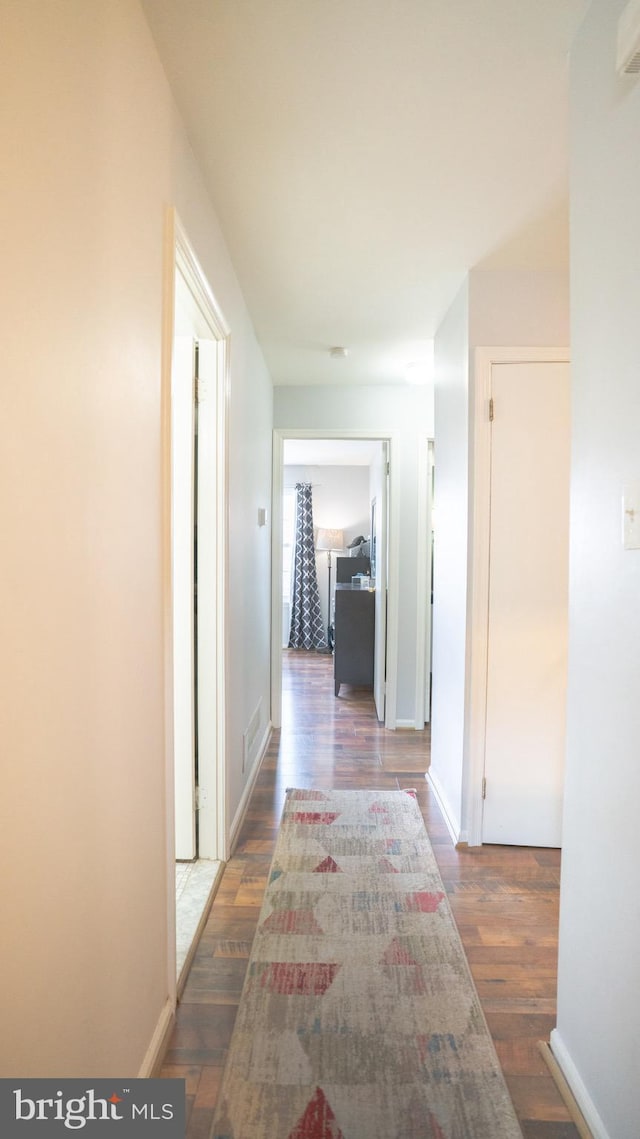 corridor with dark hardwood / wood-style flooring