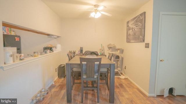 dining area featuring ceiling fan, wood-type flooring, and water heater