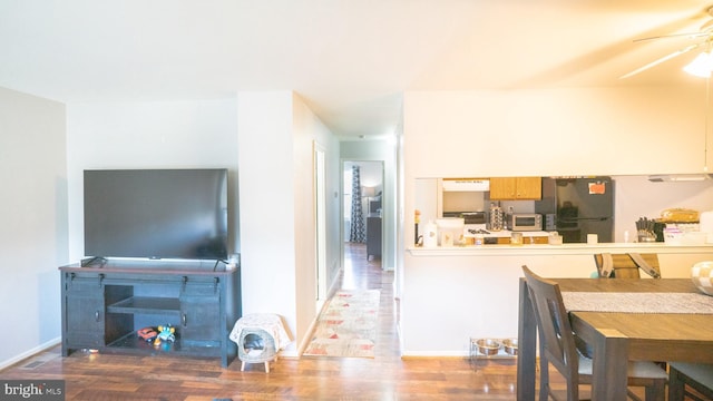 kitchen with stainless steel fridge, hardwood / wood-style flooring, ceiling fan, and range hood