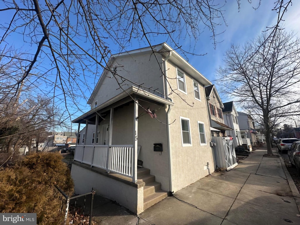 view of side of home featuring covered porch