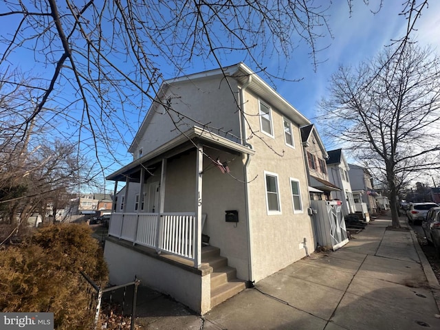 view of side of home featuring covered porch