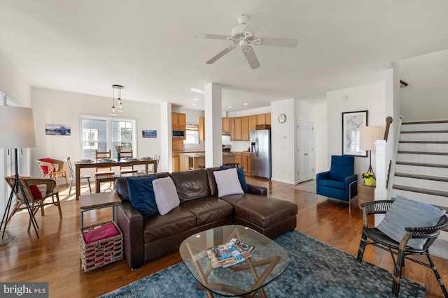 living room featuring ceiling fan and dark hardwood / wood-style flooring