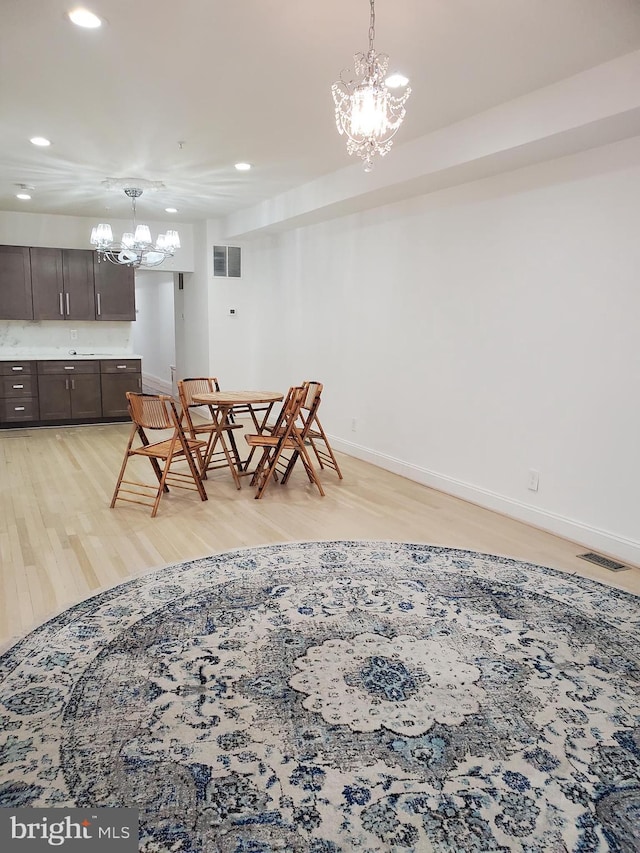 dining area with a notable chandelier and light wood-type flooring