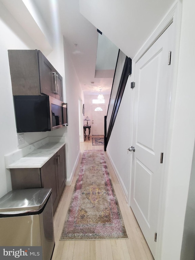 hallway with light hardwood / wood-style floors