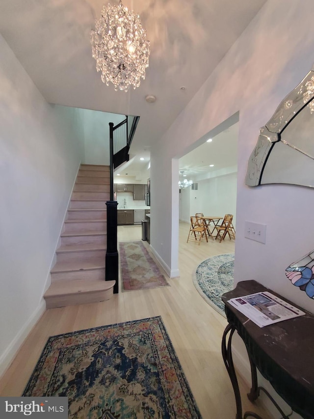 staircase featuring an inviting chandelier and hardwood / wood-style floors