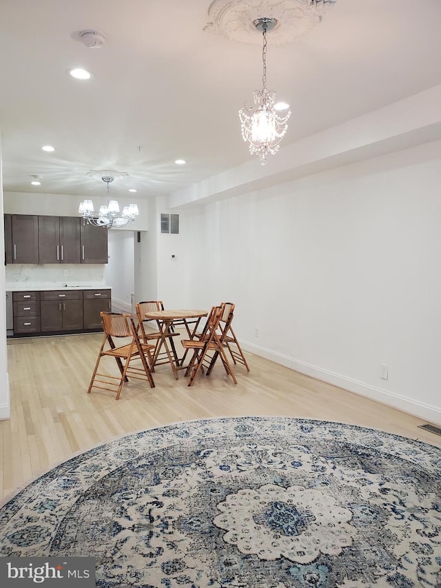 dining area with a notable chandelier and light wood-type flooring