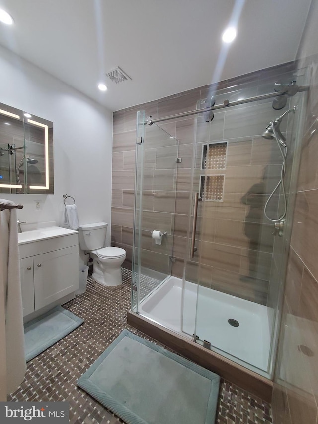 bathroom featuring an enclosed shower, vanity, and toilet