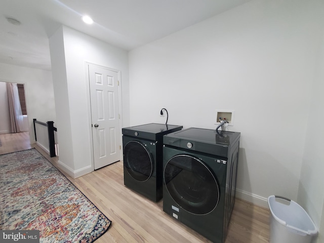 laundry room with light wood-type flooring and independent washer and dryer