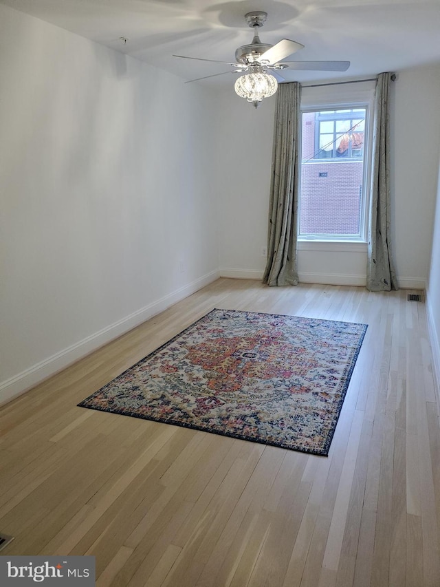 empty room with ceiling fan and light hardwood / wood-style flooring