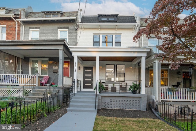 townhome / multi-family property featuring covered porch