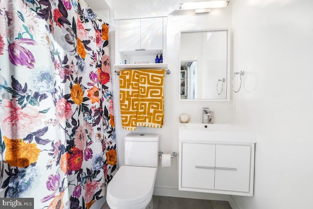 bathroom with a shower with shower curtain, vanity, and toilet