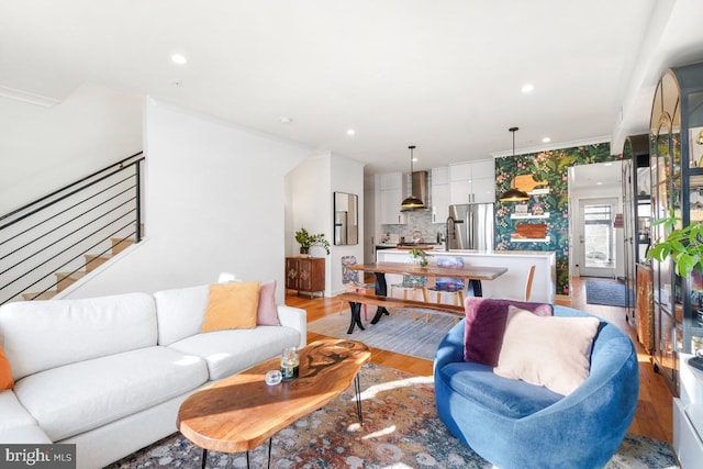 living room with ornamental molding and light hardwood / wood-style flooring